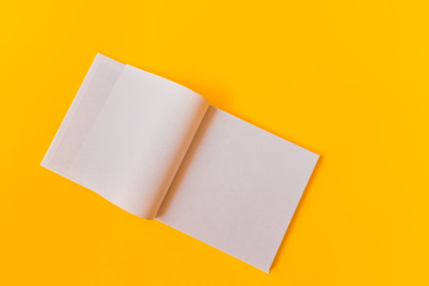用黄色背景的空白页做笔记的笔记本。图片下载