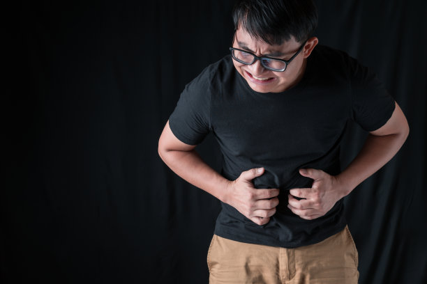 男人站着肚子疼。男人站着头痛。男人表现出不适。医疗保健与医学的概念。图片下载