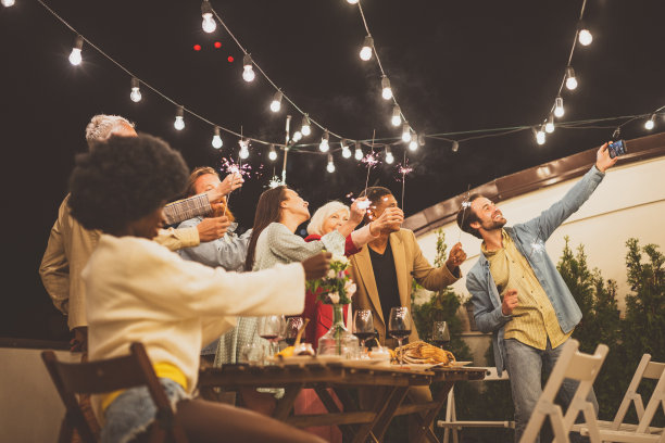 家人和朋友在屋顶露台上庆祝晚餐图片下载