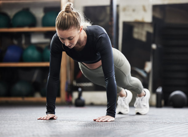这张照片拍摄的是一位运动健将在健身房做俯卧撑图片下载