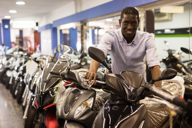 成年男子在现代陈列室购买新摩托车的肖像图片下载
