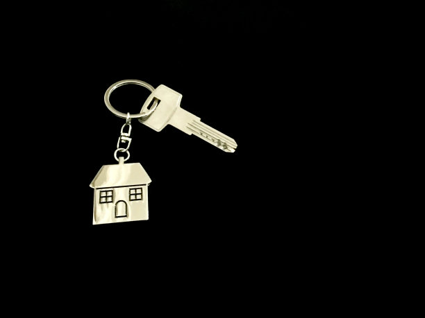 房子钥匙与房子形状的钥匙链在黑色背景图片下载