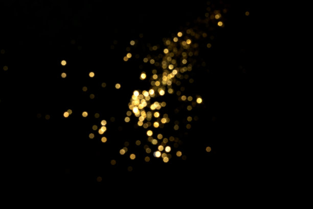 黑色背景上的金色模糊散景灯光图片下载
