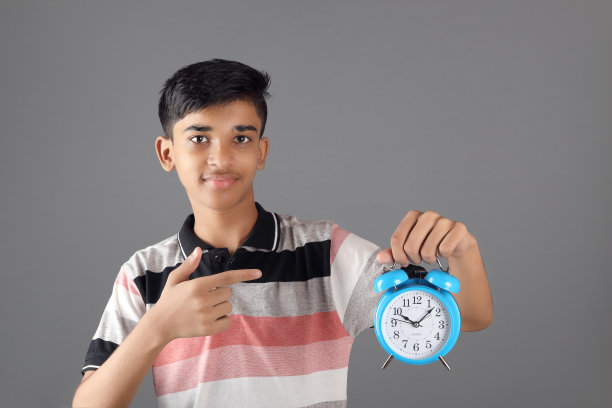 印度男孩拿着闹钟图片下载