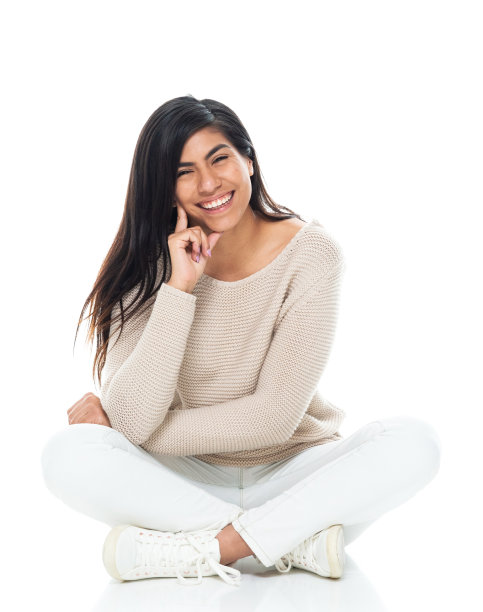 拉丁美洲和西班牙裔女性坐在地板前的白色背景，穿着毛衣图片下载