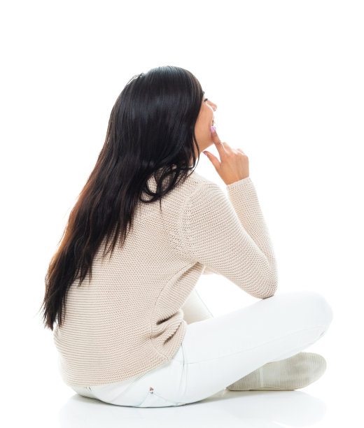 拉丁美洲和西班牙裔的年轻妇女坐在白色背景前，穿着暖和的衣服图片下载