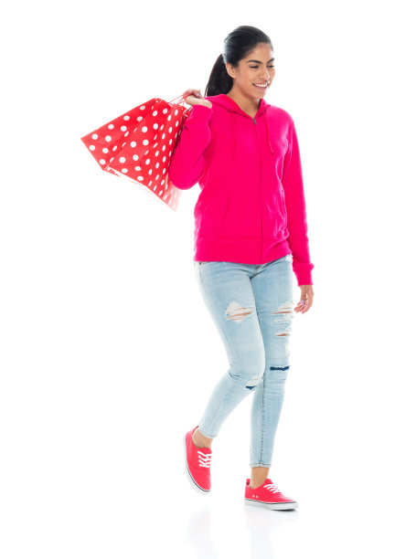 z一代年轻女性穿着帆布鞋，提着包走在白底前面图片下载