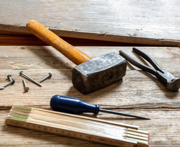 古董工具，旧的使用，锤子，钳子和钉子在木头上，工作长凳桌子。图片下载