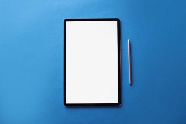 黑色屏幕现代平板设备与反射和银色笔在蓝色表面图片下载