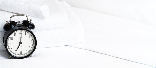 床上黑色金属闹钟，显示7点图片下载