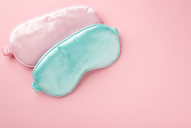 俯视图照片的两个浅粉色和蓝色丝绸睡眠面具在孤立的淡粉色背景与copyspace图片下载
