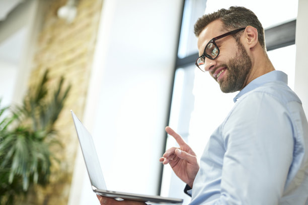 在工作中使用现代电子设备的愉快的办公室员工图片下载