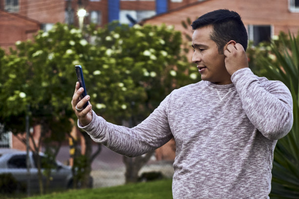 一个男人在屋外给他的工作单位打电话，要参加一个重要的会议图片下载
