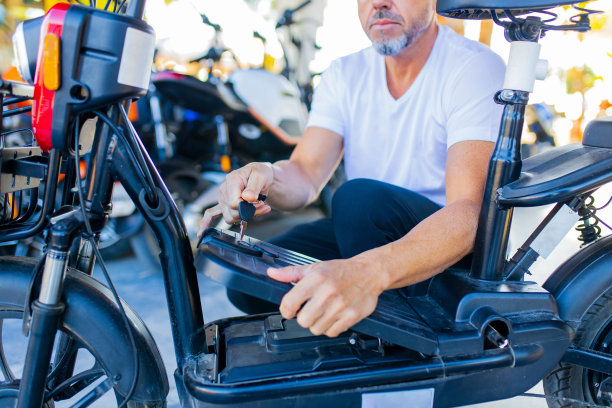 近距离拍摄男性手充电电动滑板车的过程图片下载