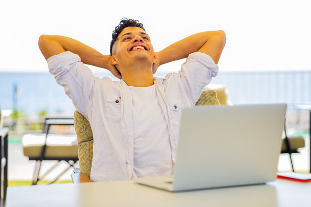 快乐的阿根廷学生在户外用笔记本电脑犯罪，看起来很高兴图片下载