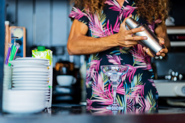 帅气的卷发调酒师在度假酒吧准备鸡尾酒图片下载