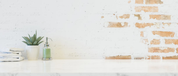 有复制空间的桌面，白色砖墙上的洗发水瓶。图片下载