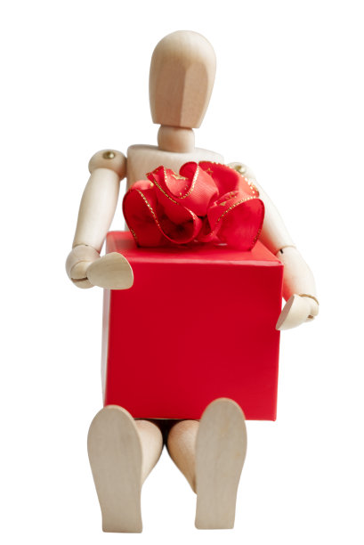 木制假人持有礼盒与红色弓孤立在白色图片下载