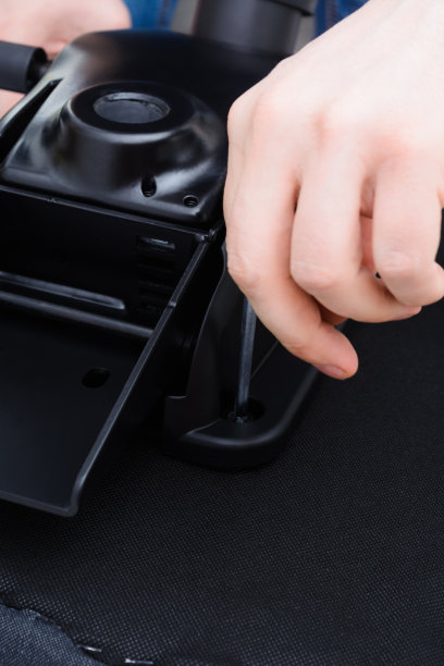 白人男子双手螺旋升降椅机构。组装的办公椅图片下载