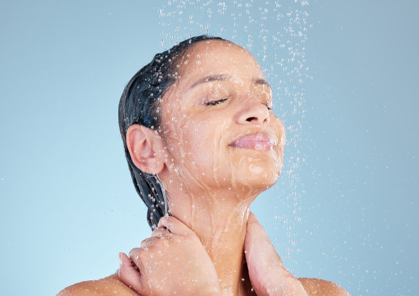 工作室拍摄的一个迷人的年轻女子在蓝色的背景下洗澡图片下载