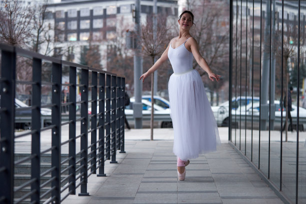 美丽的芭蕾舞演员在城市里跳舞。图片下载