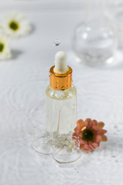 皮肤保湿精华液站在水与花在白色背景。图片下载