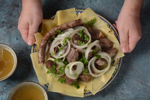 手抓肉：哈萨克斯坦民族特色菜，配肉和面食。盘中特写：大块炖肉和洋葱图片下载