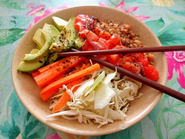 五颜六色的鱼，蔬菜餐盘，胡萝卜，鳄梨，竹子，用筷子吃，放在花卉图案的桌布poké碗开胃室内照片新鲜的生的自制图片下载