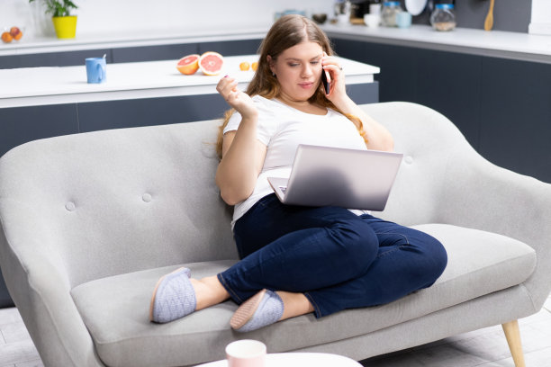 工作紧密联系的概念。与营养学家通电话在笔记本电脑上看着项目一个在隔离期间呆在家里的小胖女孩。自我隔离作为预防。工作非常遥远的概念图片下载