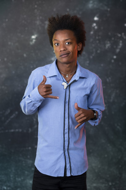 年轻的黑人男孩看向别处，背景是灰色的纹理。图片下载