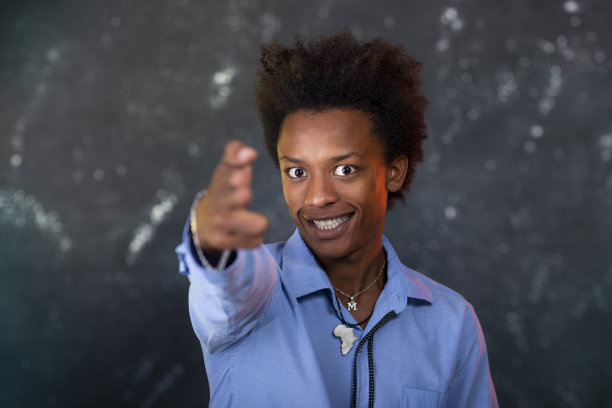 看着镜头微笑的年轻黑人男孩，纹理灰色背景图片下载