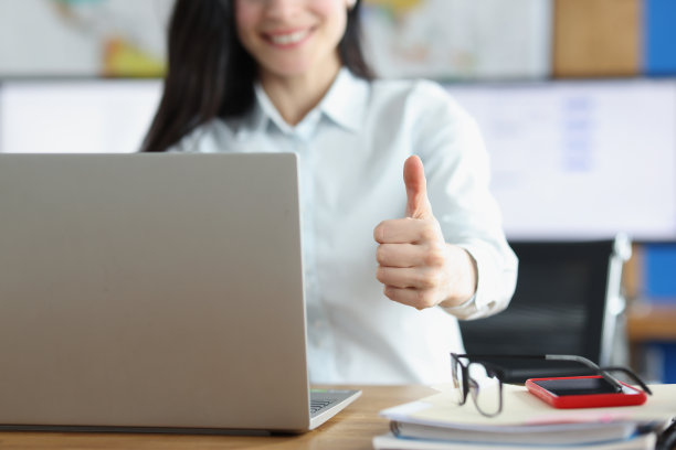 办公室职员竖起大拇指在笔记本电脑上工作图片下载
