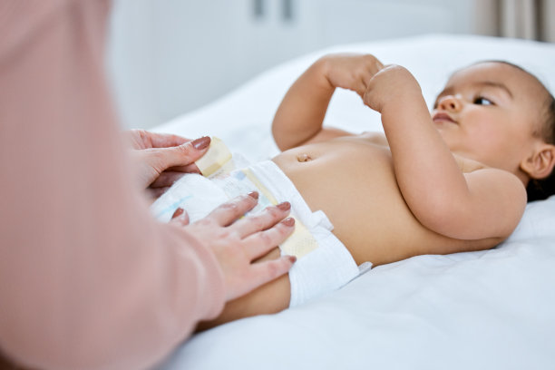 一张母亲给婴儿换尿布的照片图片下载