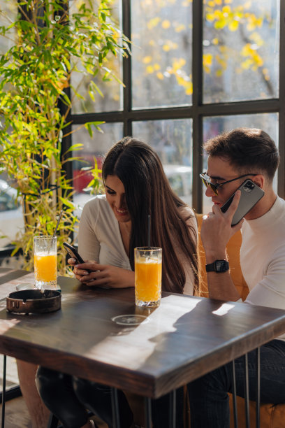 朋友们聚在一起，在咖啡馆里喝着咖啡，谈笑风生。男女朋友在阳光明媚的日子里一起拍照。图片下载