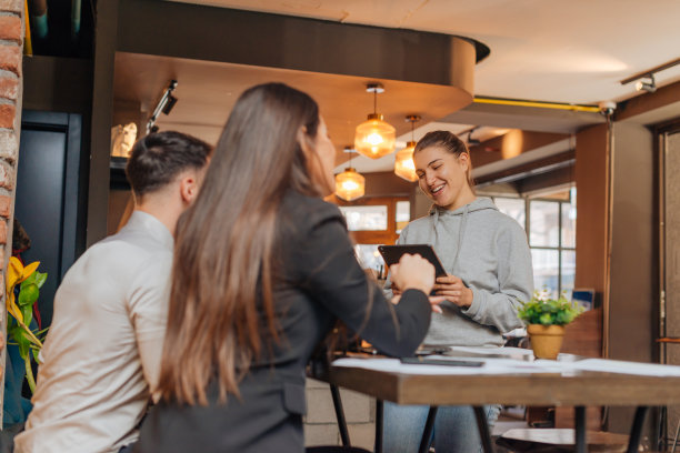 成功的年轻企业家在咖啡馆里分享想法，微笑着一起做一个项目。图片下载