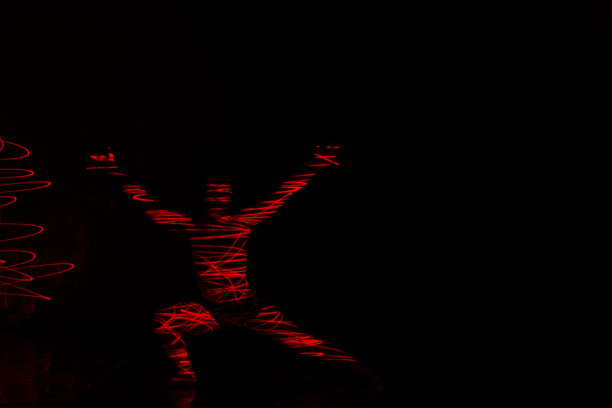 芭蕾舞演员在红灯前跳舞，用华丽的舞蹈动作表达地狱。图片下载