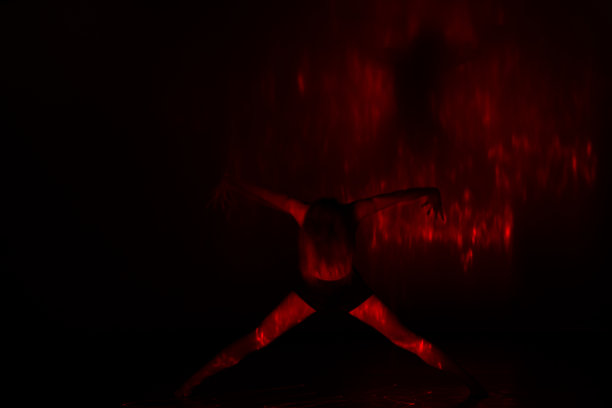 一位英俊的女舞者展示了她的身体和大量的红色激光，以艺术的方式表现了地狱。图片下载