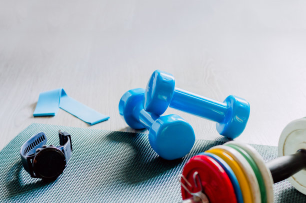 健康的一天。在地板上放一些蓝色的哑铃和橡胶垫。在家健身。健身类。健康和运动理念。图片下载