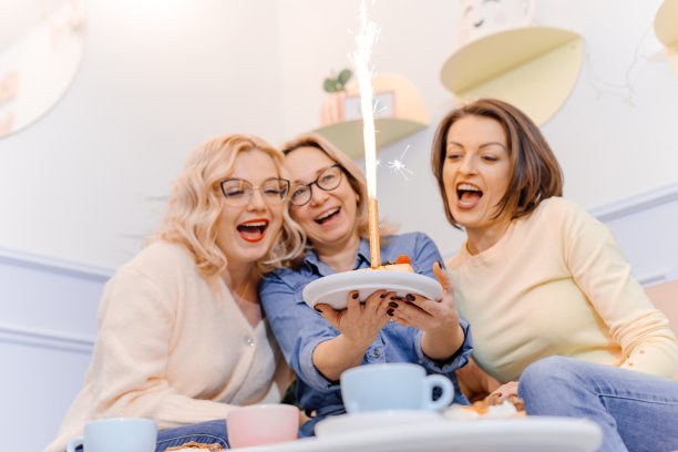 一群欢快的女性朋友欢聚一堂，庆祝朋友的生日，唱生日歌图片下载