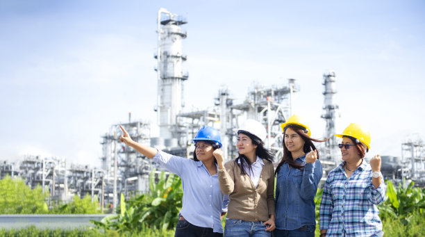 工程师戴着安全帽在炼油厂和天然气工业前的双重曝光——夕阳背景下的炼油厂，商业工业路线概念图片下载