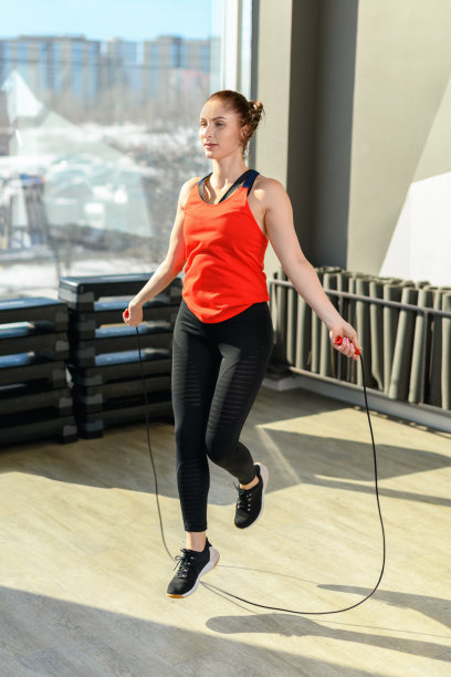 健身房里跳绳的女孩，中年健身女士。运动和健康的生活方式理念。动态运动图片下载