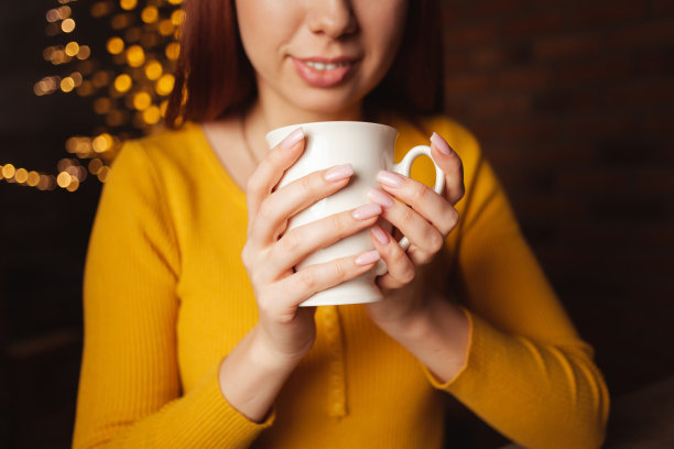 女人泡茶，香喷喷，开胃。白瓷杯，饮品，茶馆。温馨的气氛，节日的背景。温暖的手,微笑图片下载