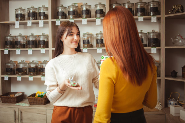 女人在茶馆挑选礼物，漂亮的节日包装。卖方提供的货物。私营小企业，企业家。微笑，幸福，好心情图片下载