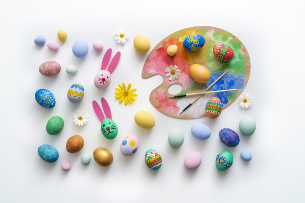 复活节彩蛋上手绘有兔子的脸和耳朵，白色的雏菊花图片下载