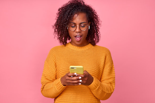 非洲裔美国女性在智能手机的屏幕上，对短信内容印象深刻图片下载