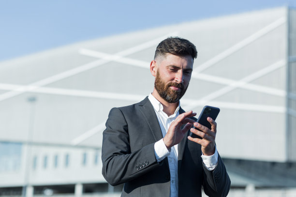 有胡子的成功商人在办公室外使用电话图片下载