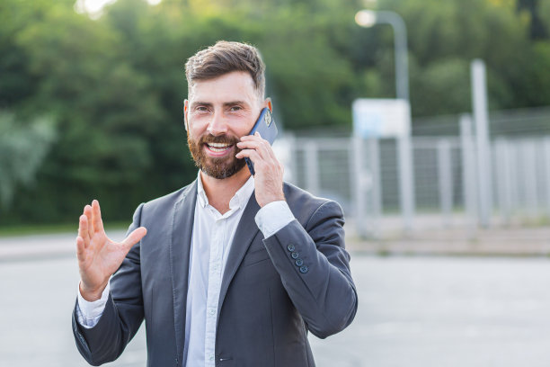 一个满脸胡须的快乐商人的肖像，一个男人的特写照片，微笑着看着相机，打电话图片下载