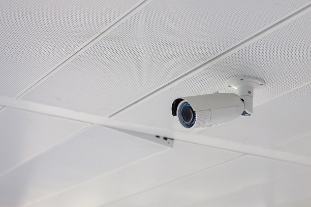 现代化的安全摄像头，具有办公室或住宅背景，闭路电视记录和停车场的财产保护图片下载