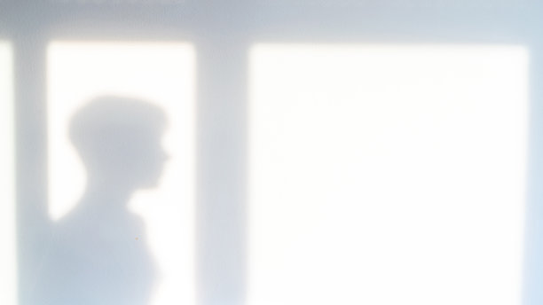 影子楼。抽象的光，黑色阴影覆盖窗口上的白色纹理墙。阳光建筑背景。照片和设计的叠加效果。图片下载