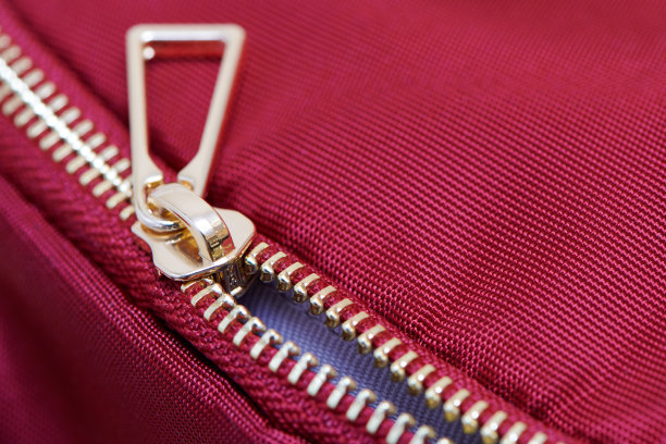 金色拉链近距离观察。背包或衣服上没有完全扣上金属拉链。图片下载